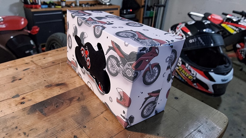 Box with motorcycle design on a wooden table in a garage setting