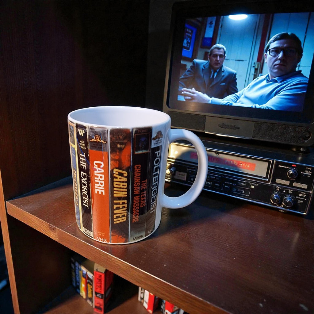 Mug with book cover designs on a shelf with a television playing a scene.