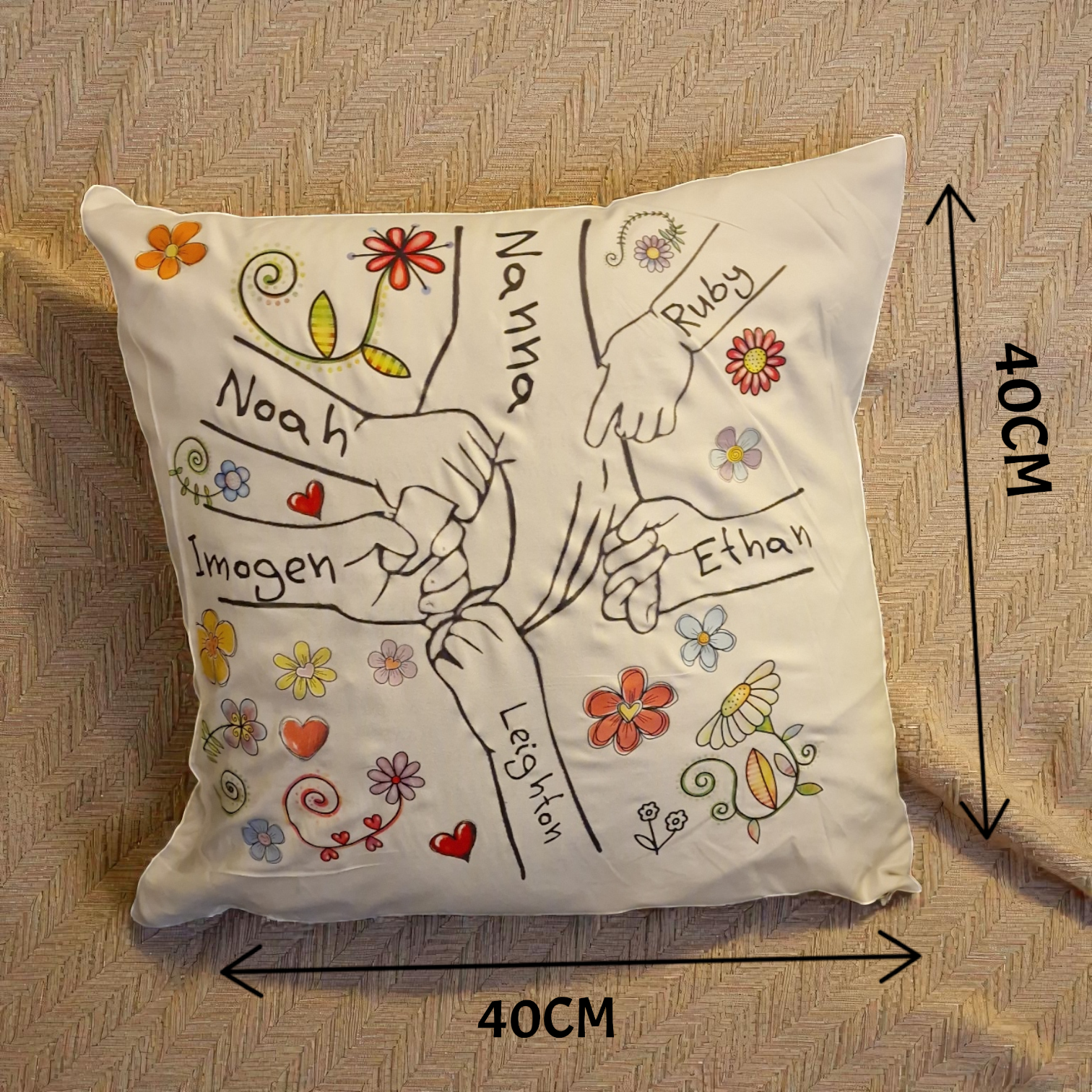Decorative pillow with hand-drawn designs and names on a textured surface