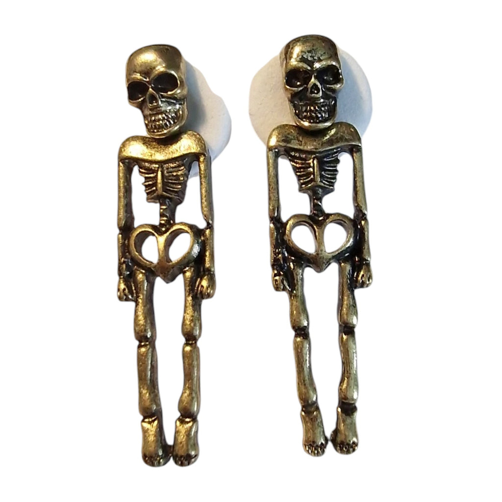 A pair of dangling skeleton-shaped earrings in an antique gold finish, displayed against a plain white background.