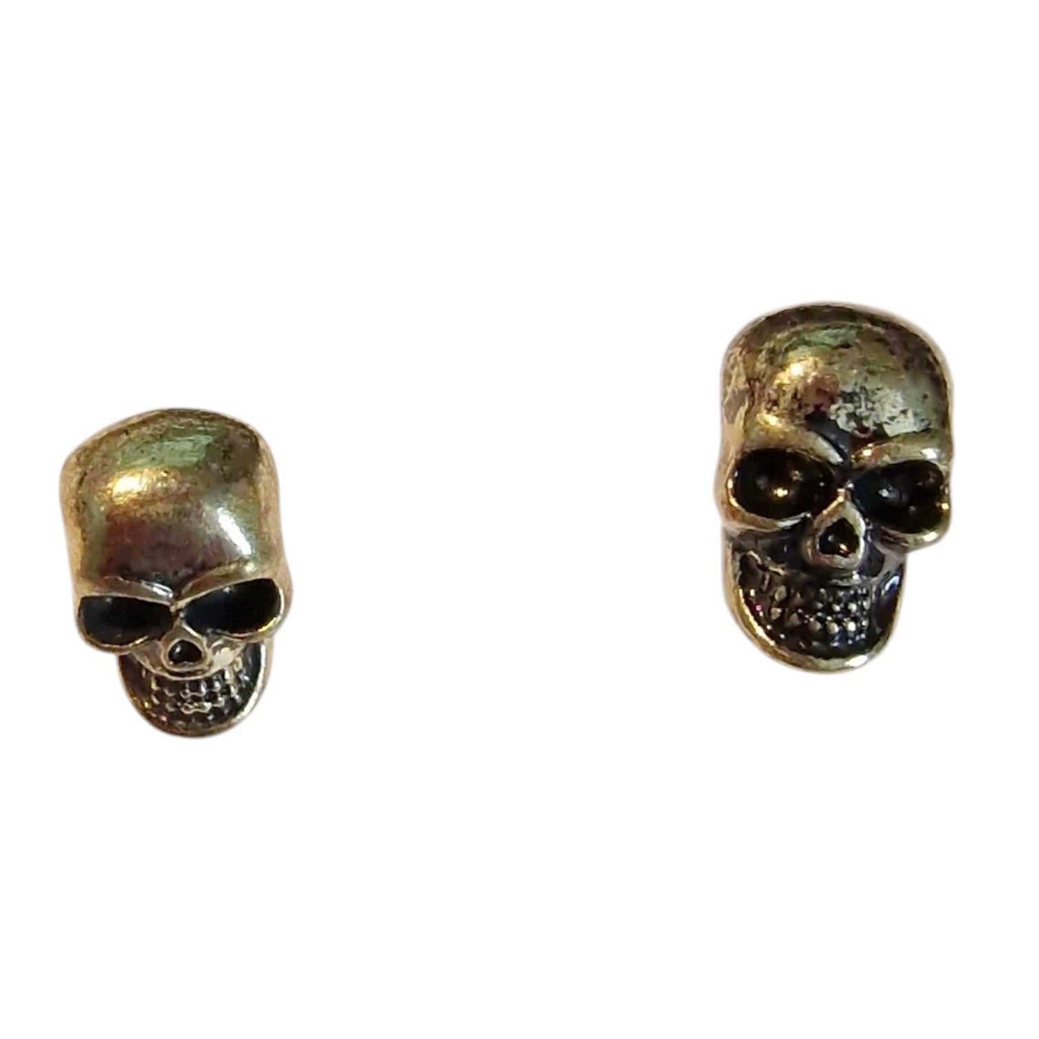 A pair of antique bronze skull stud earrings on a plain white background.