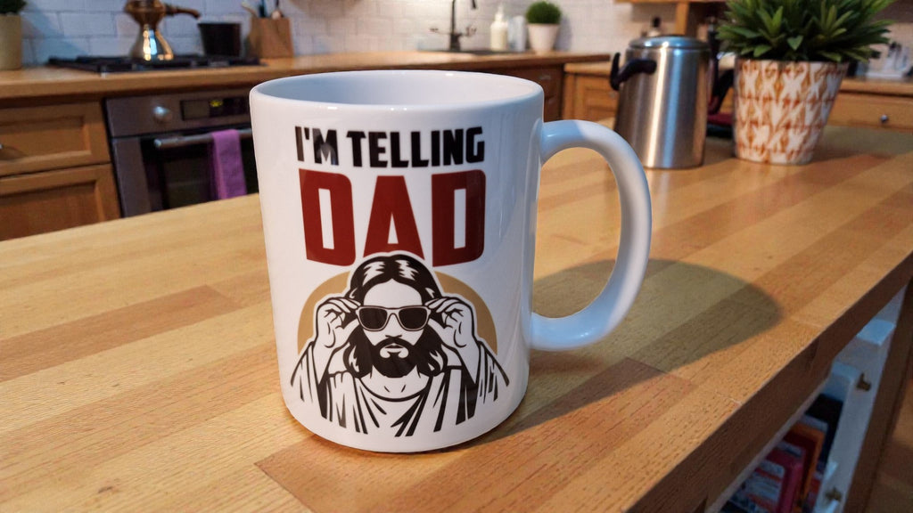 White mug with text 'I'm Telling Dad' and a graphic of a person wearing sunglasses on a white background.