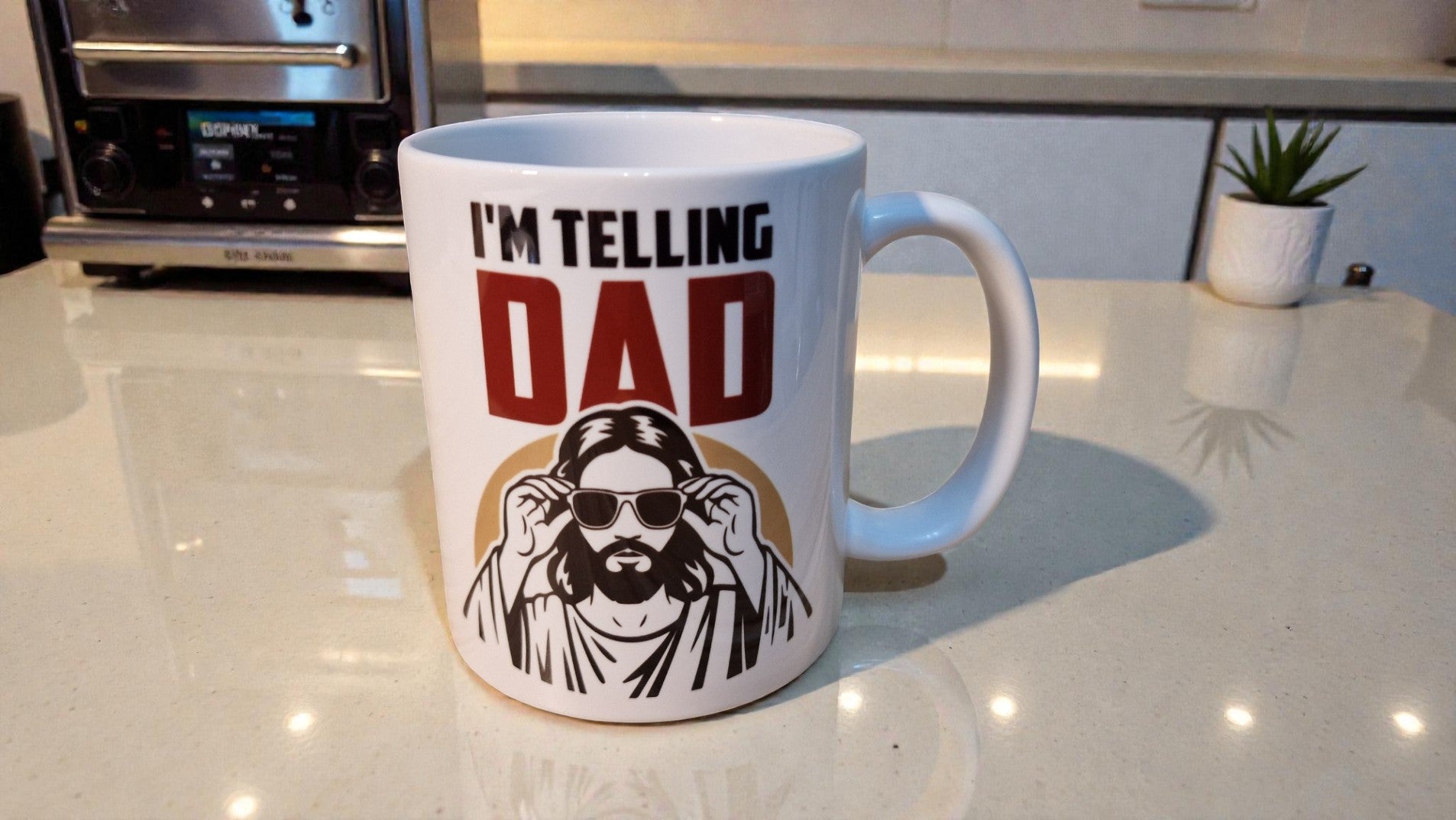 Mug with 'I'm Telling Dad' text and graphic on a kitchen counter