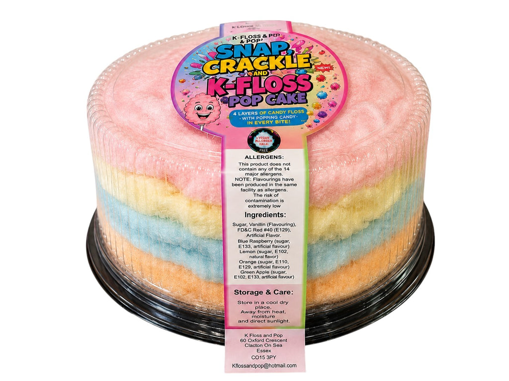 A round, multi-colored cotton candy cake in a clear plastic container with a black base, featuring a colorful paper label that reads 'Flavors by Pop! Snap Crackle K-Floss Pop Cake'. The cotton candy layers are pastel pink, yellow, and light blue.