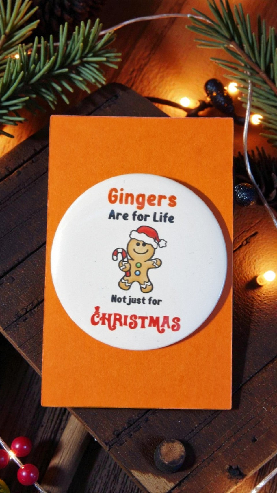 Card with gingerbread man illustration and text on an orange background, surrounded by Christmas decorations.