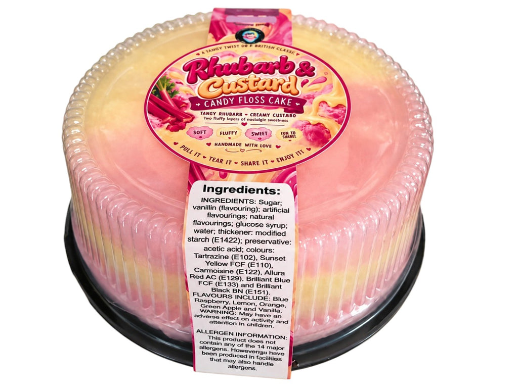 A packaged two-tone candy floss cake in a clear plastic tub with a decorative scalloped rim. The top half is creamy yellow, and the bottom half is light pink, with a large pink and yellow label reading 'Rhubarbs & Custard Candy Floss Cake' and a white ingredients tag on the front.