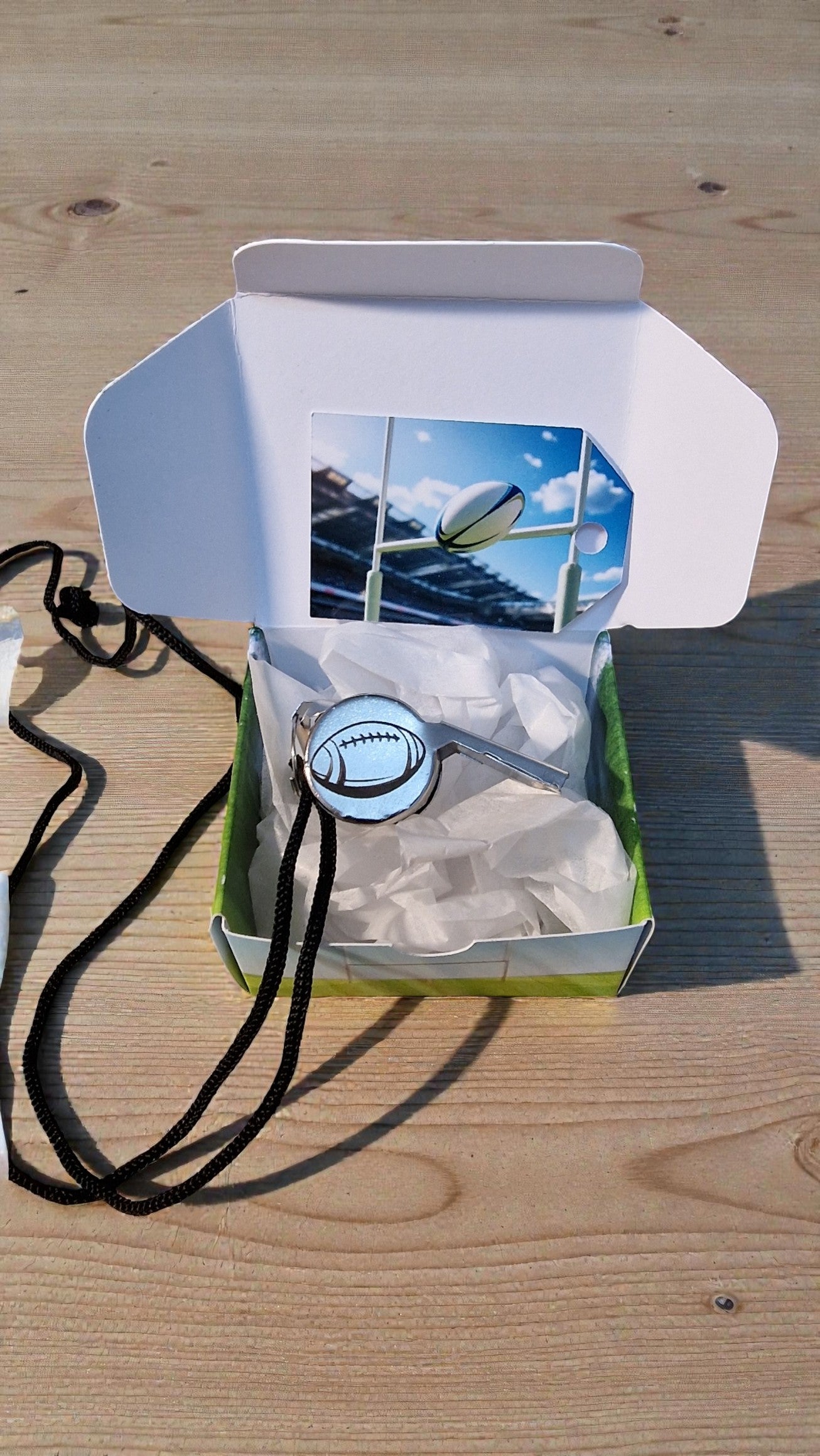 Packaged product with a lanyard on a wooden surface