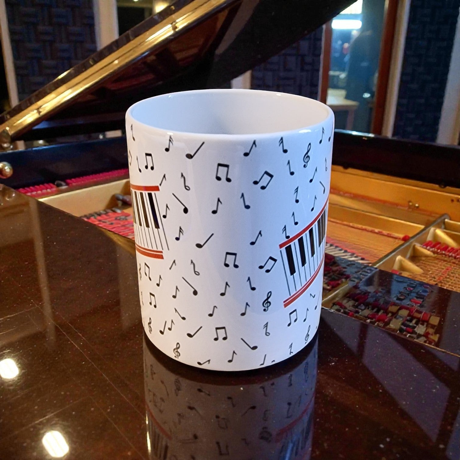 Mug with musical note design in front of a grand piano