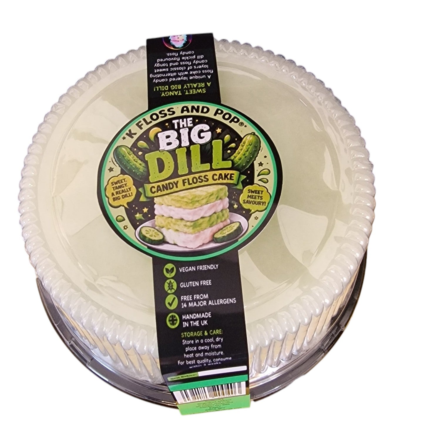A round plastic tub of K Floss and Pop 'The Big Dill' Candy Floss Cake, featuring a black and green paper label with product details and a small illustration of a layered cake.