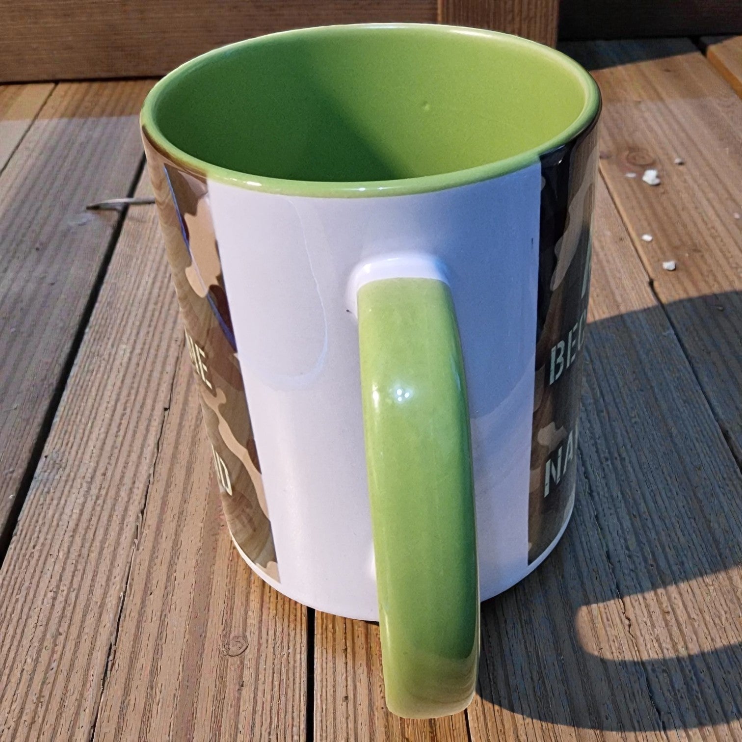Green and white mug on a wooden surface