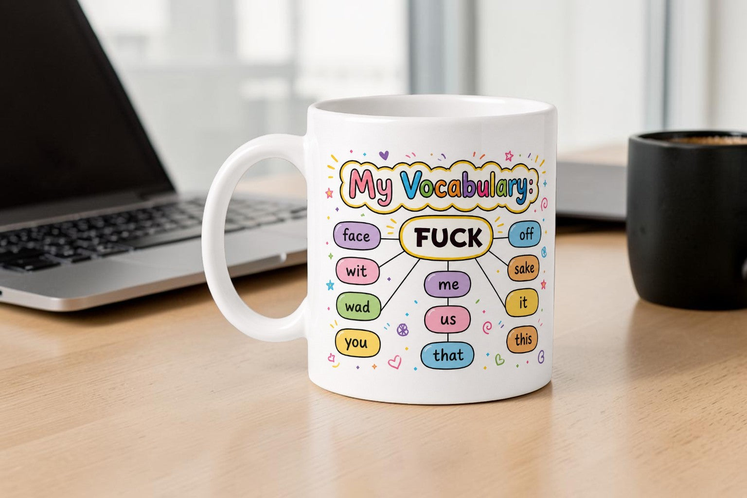 Mug with colorful vocabulary diagram on a desk next to a laptop