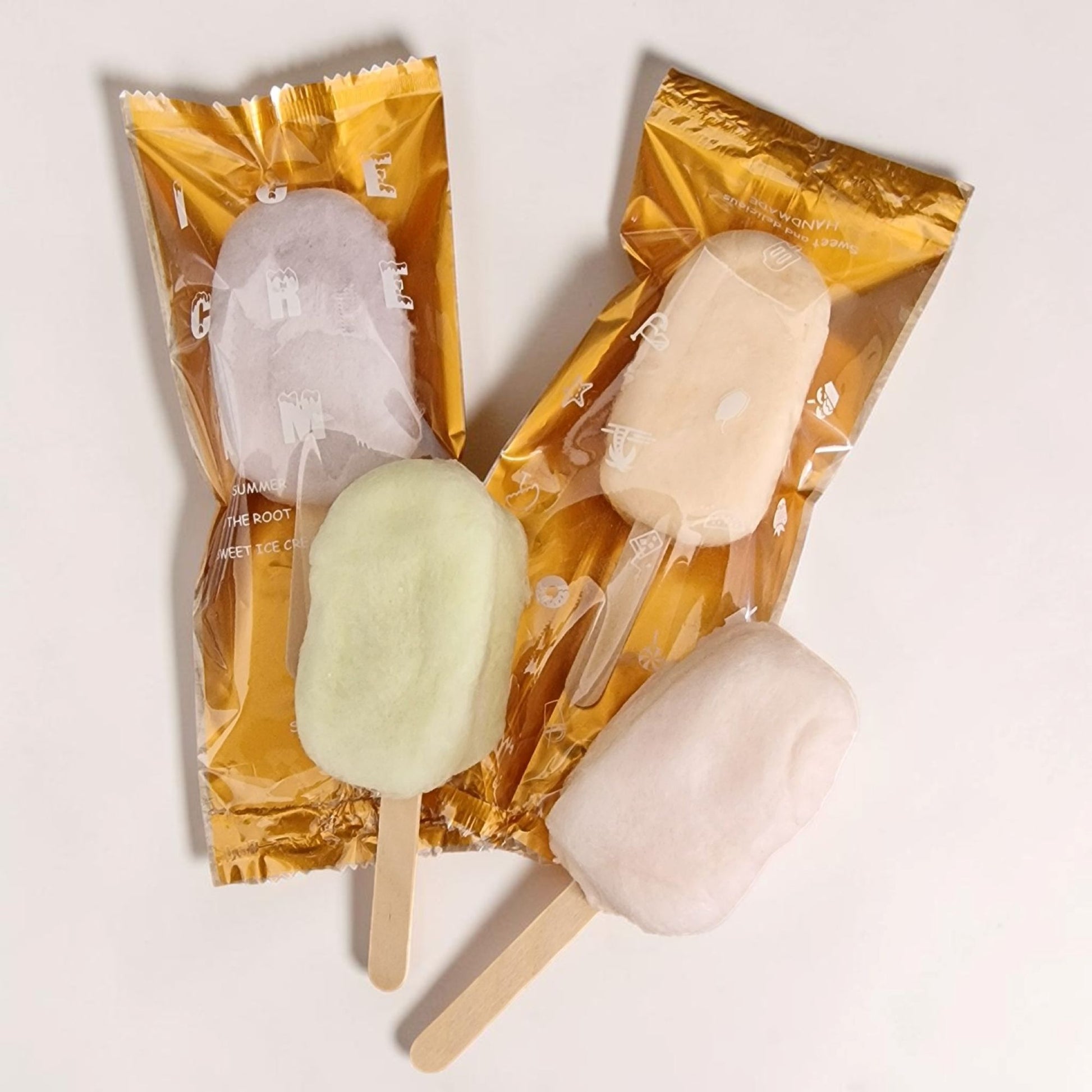Two popsicles in their packaging on a light background