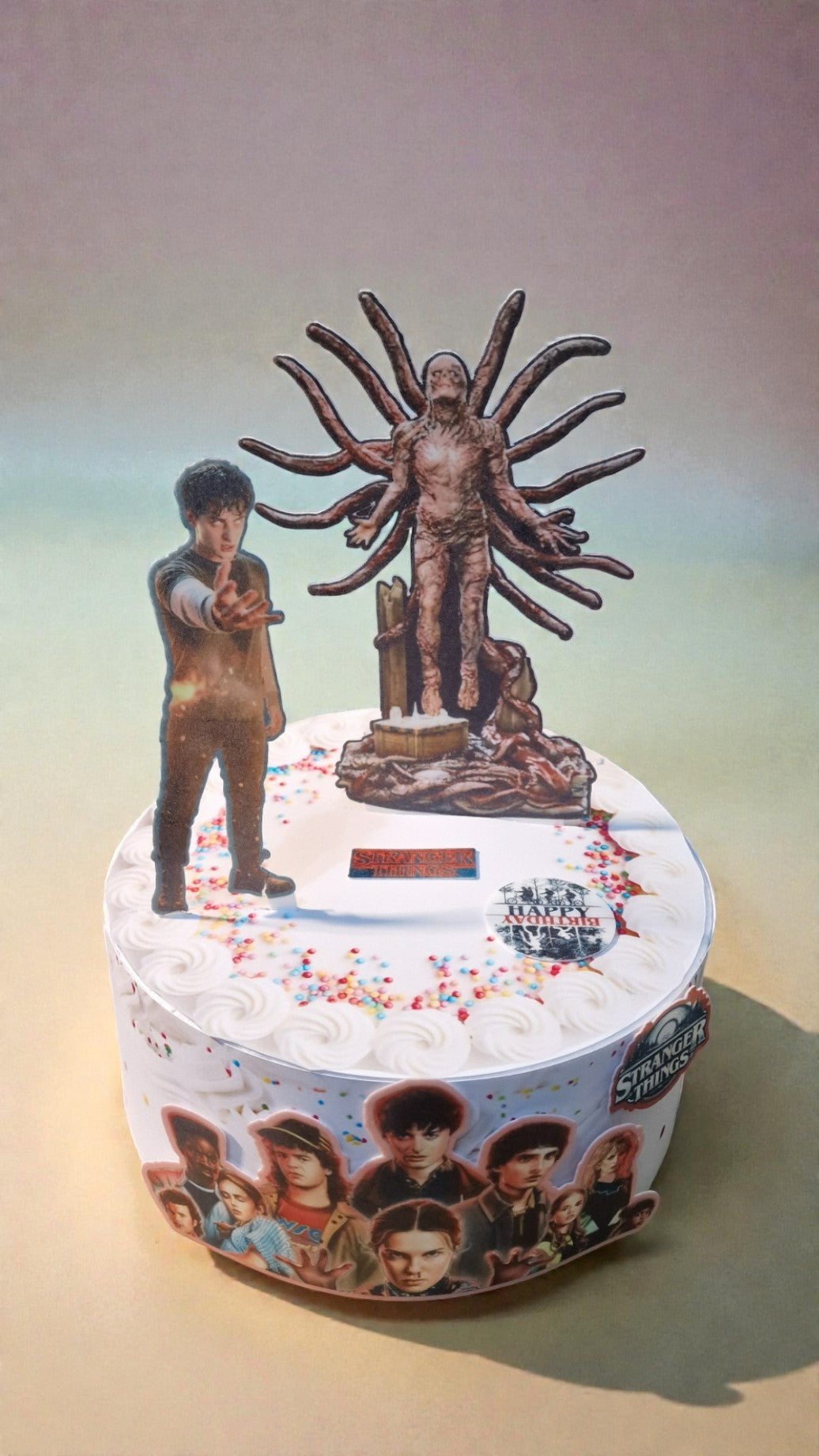 Decorative cake with a statue and people on top, featuring a gradient background.
