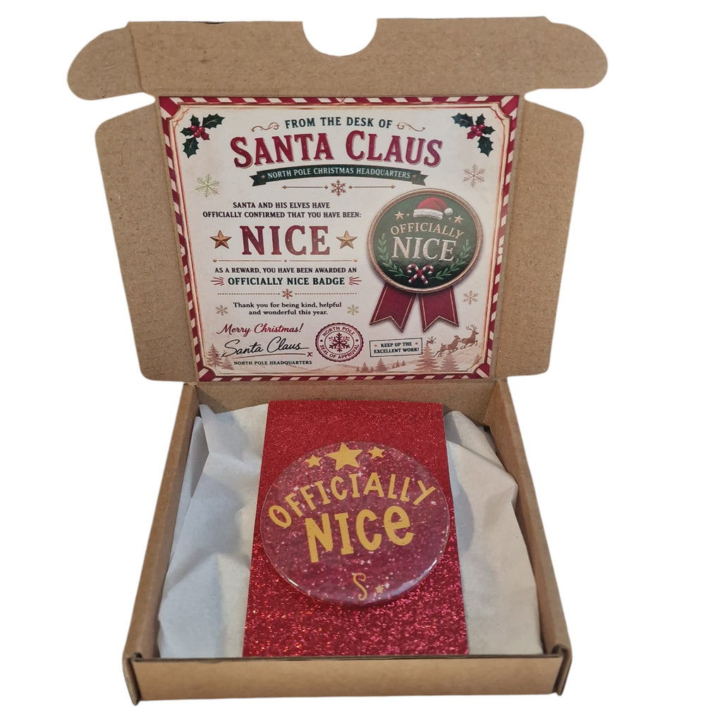 Box containing a 'From the Desk of Santa Claus' badge and card with a 'Officially Nice' badge.