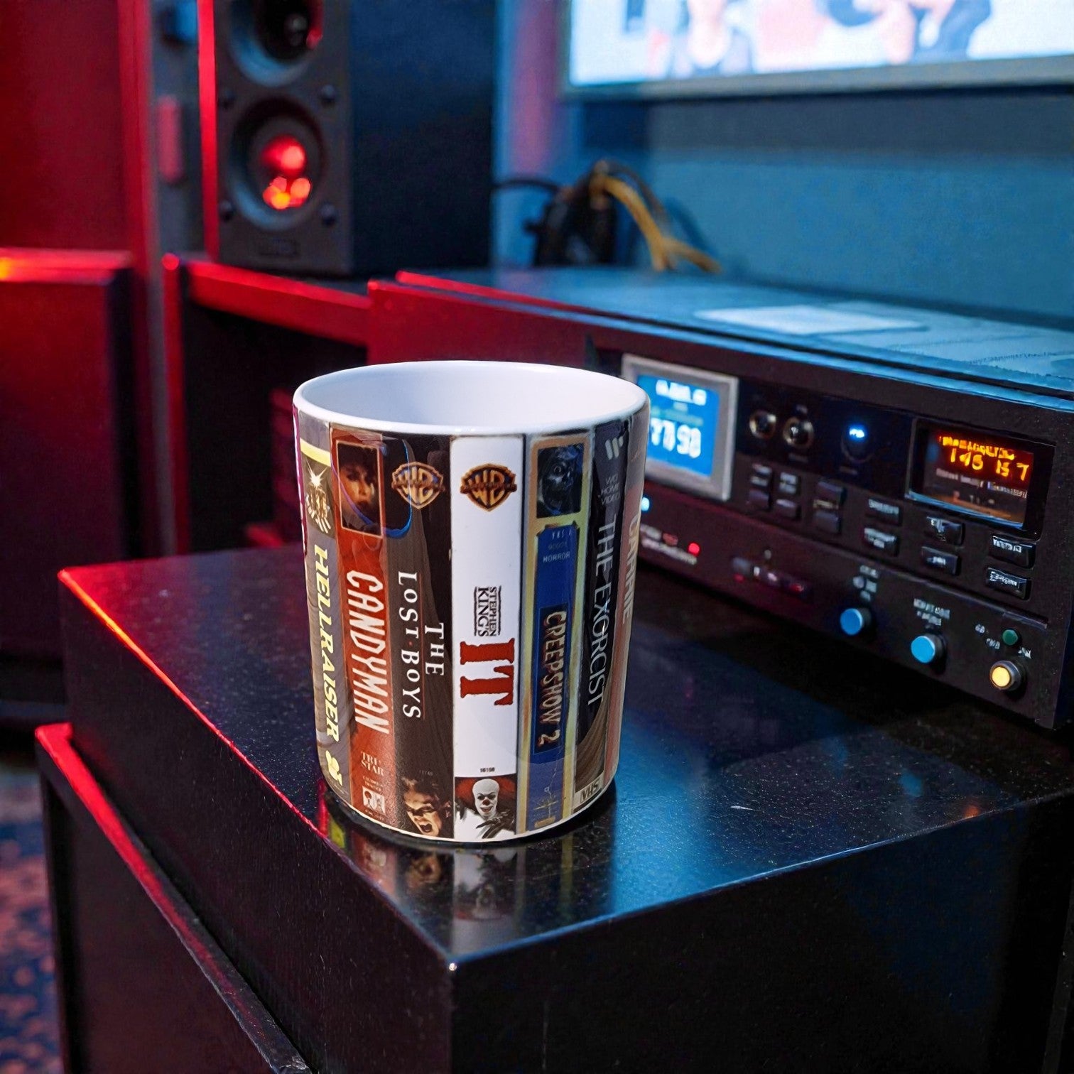 Cup with movie cover design on a table next to audio equipment